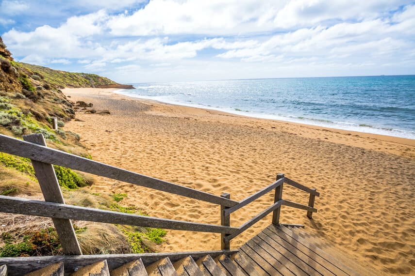 Wooden steps leading down to Bells Beach with the ocean on the right on the Great Ocean Road Australia