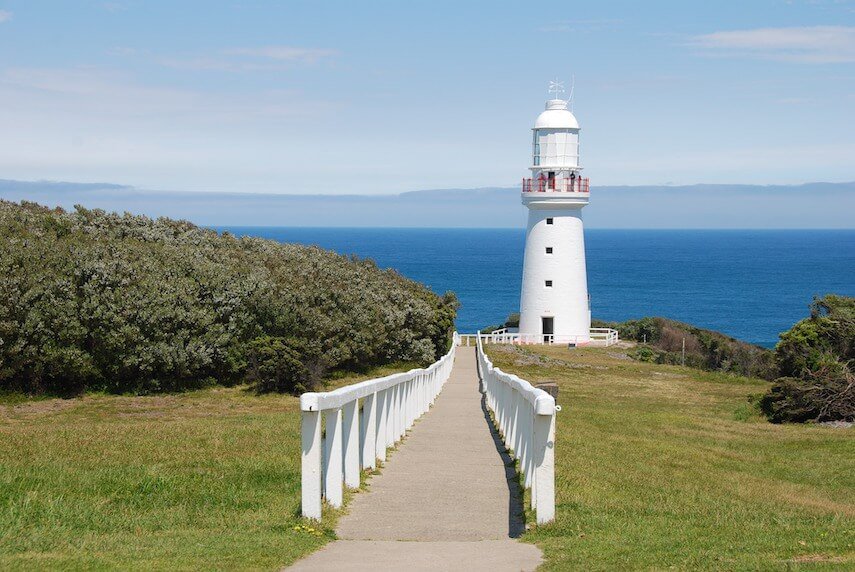 Cape Otway Lighthouse from the top of the white fences path leading down to it with the ocean in the background