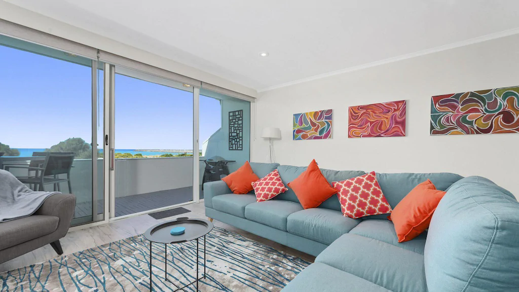 Living room with floor to ceiling windows in Foreshore Apartment
